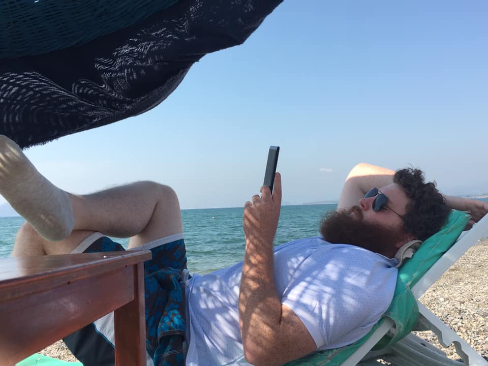 Patrick Corbett reading a book on a sunlounger